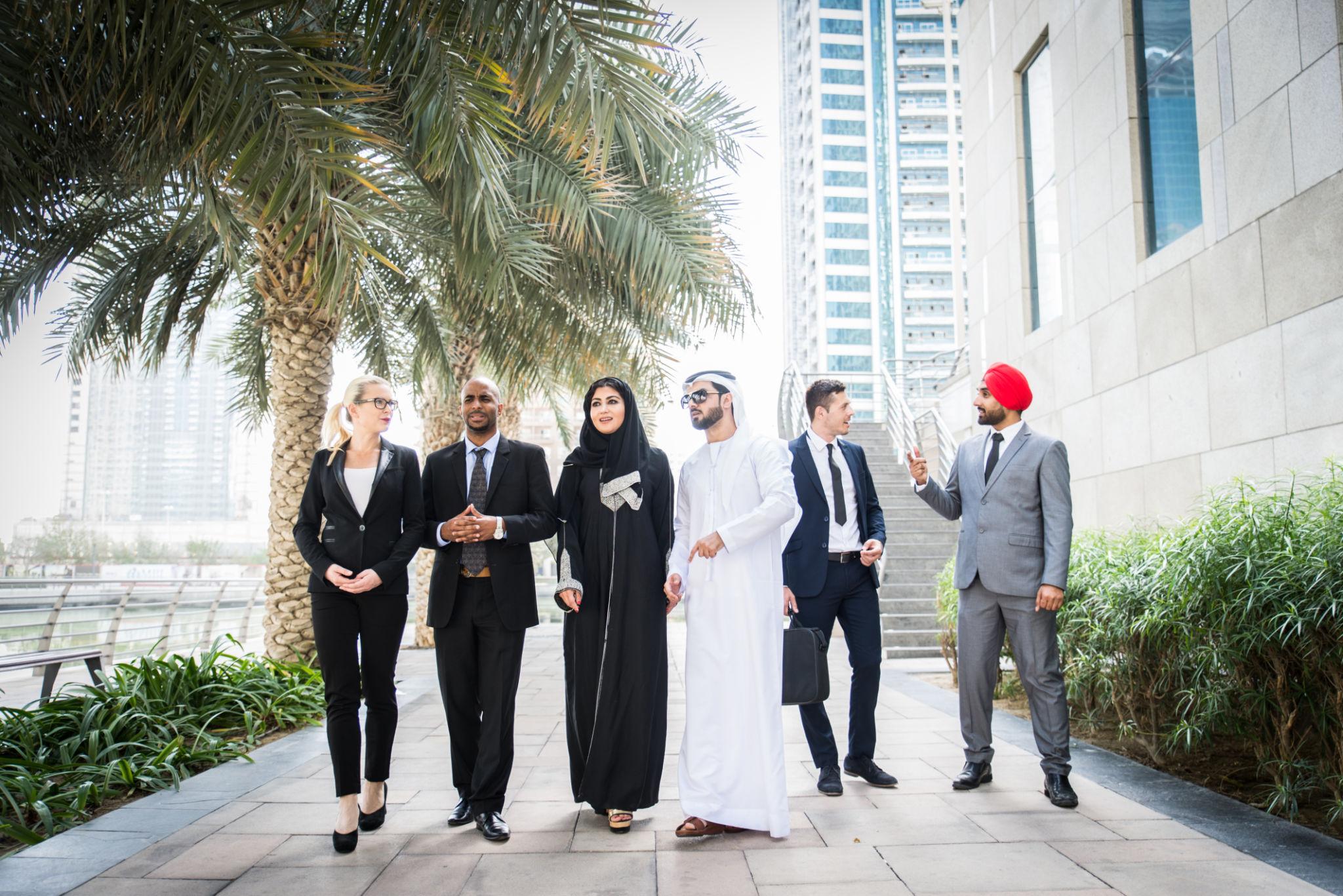 QuickPlus team walking through a Dubai business district
